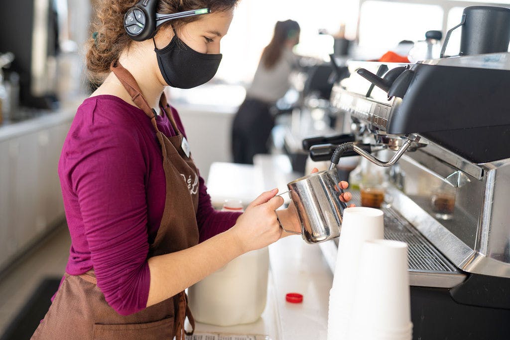 a woman standing in front of a blender