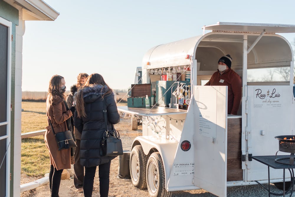 a group of people standing outside of a food truck