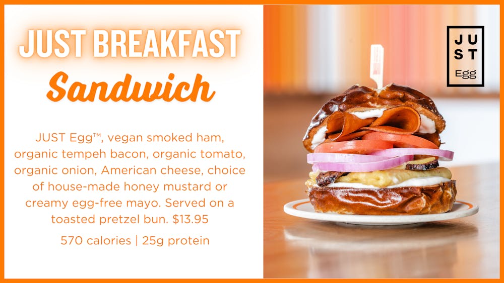 JUST Breakfast Sandwich: JUST Egg™, vegan smoked ham, organic tempeh bacon, organic tomato, organic onion, American cheese, choice of house-made honey mustard or creamy egg-free mayo. Served on a toasted pretzel bun. $13.95     570 calories | 25g protein
