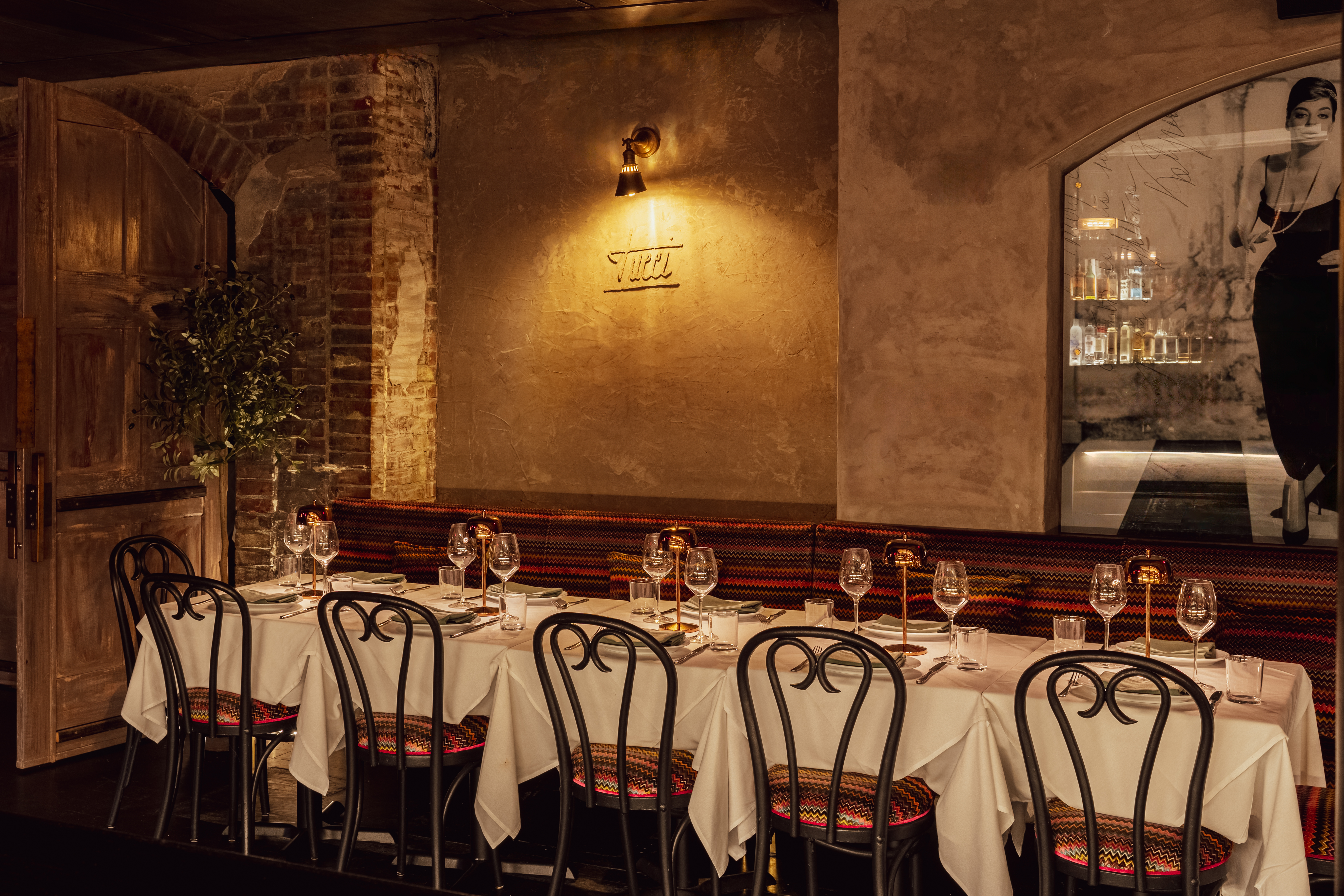 Private dining room at Tucci NYC with brick arches, candlelight, and warm ambiance in NoHo Manhattan