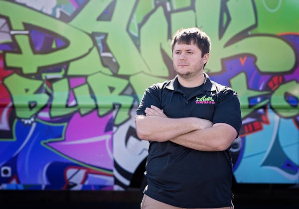 Robert McGinnis standing in front of a graffiti covered wall