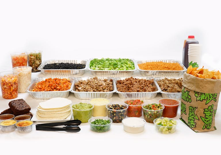 a table full of food on catering trays