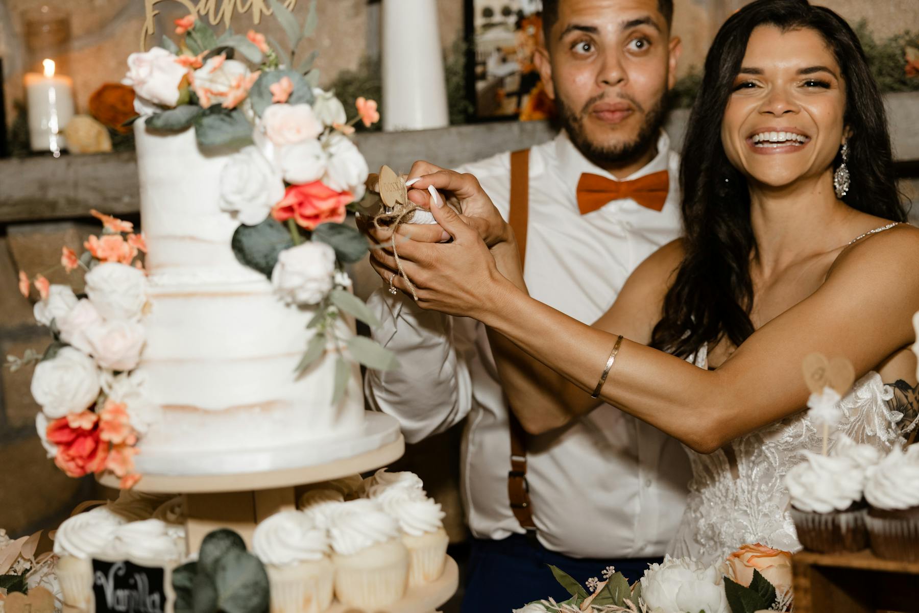 a person cutting a wedding cake