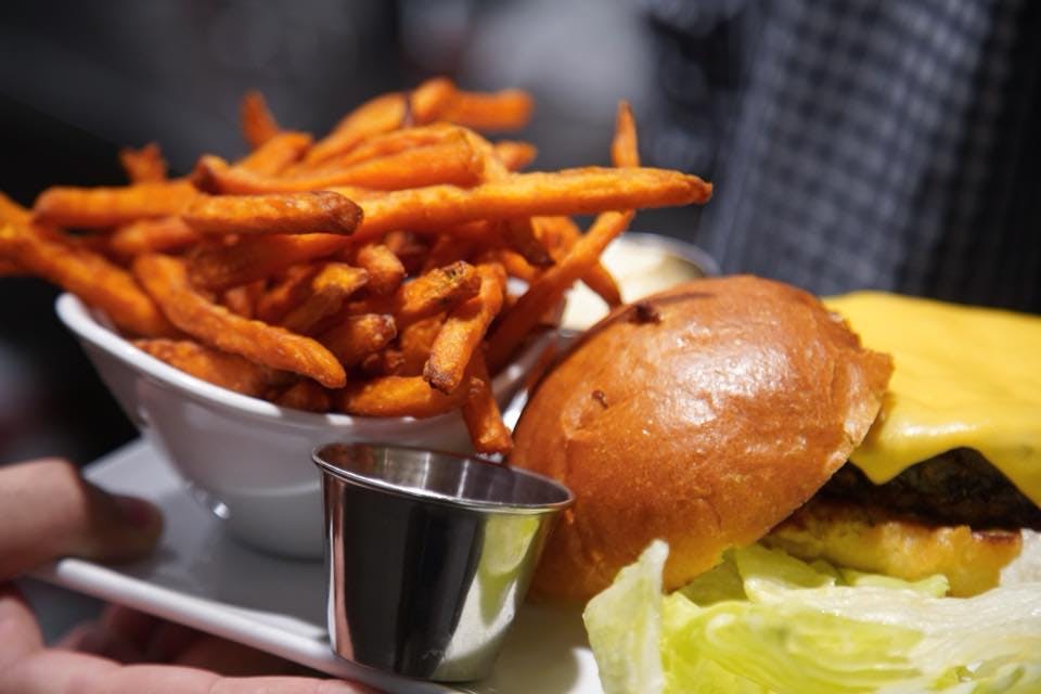 a close up of a plate of burger and french fries