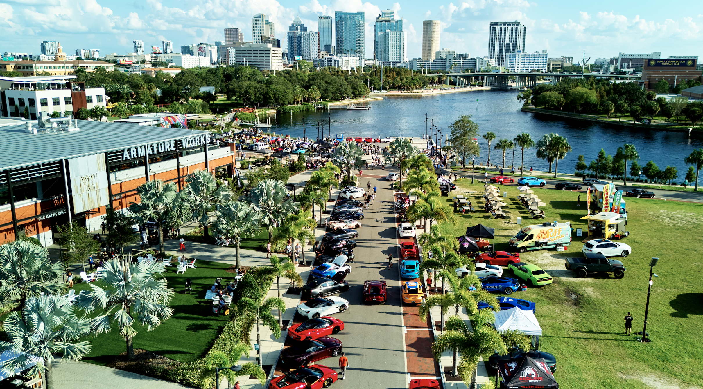 cars parked cars on the road near a body of water