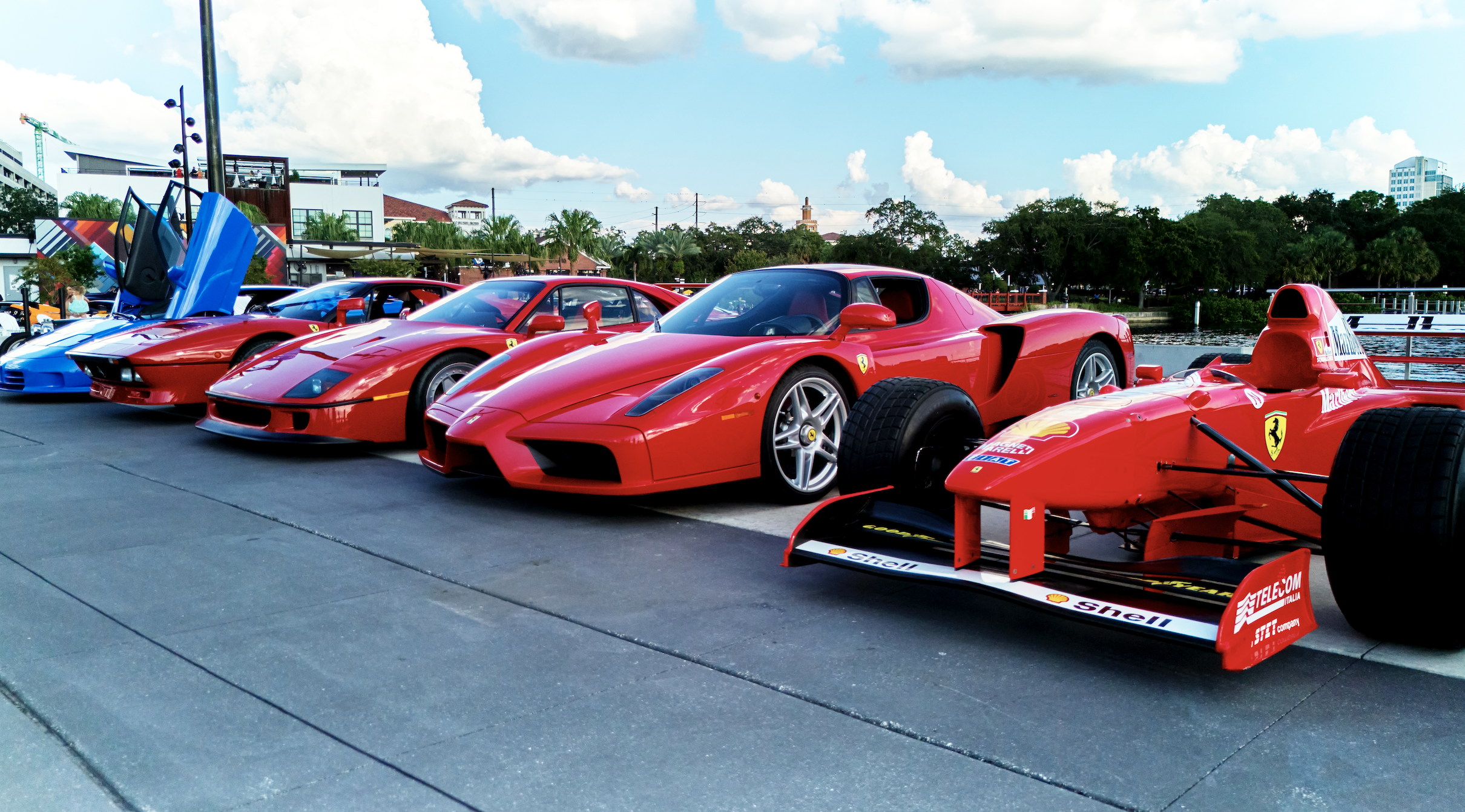 a group of red sports cars parked on a road