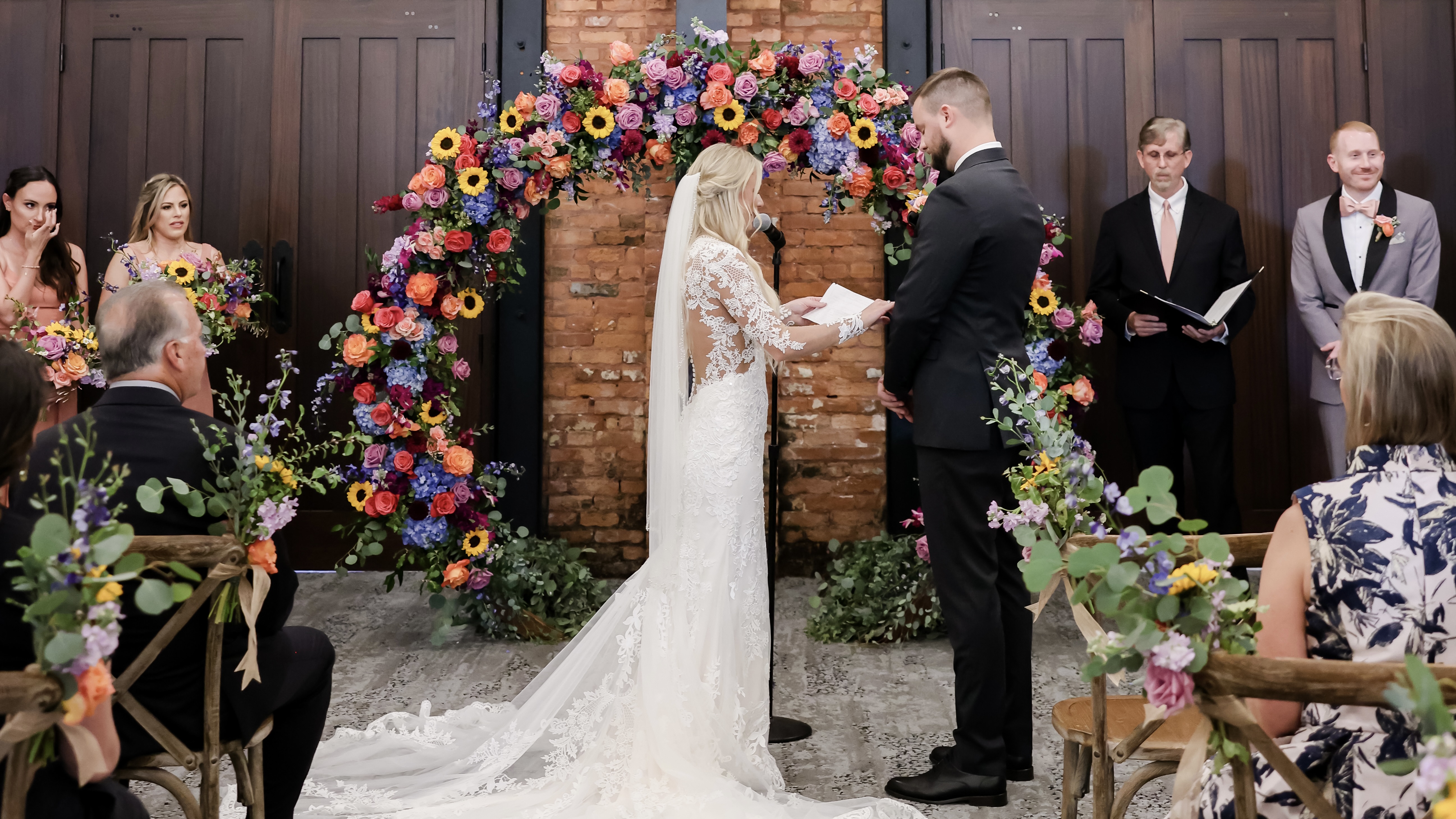 a group of people standing in front of a wedding cake