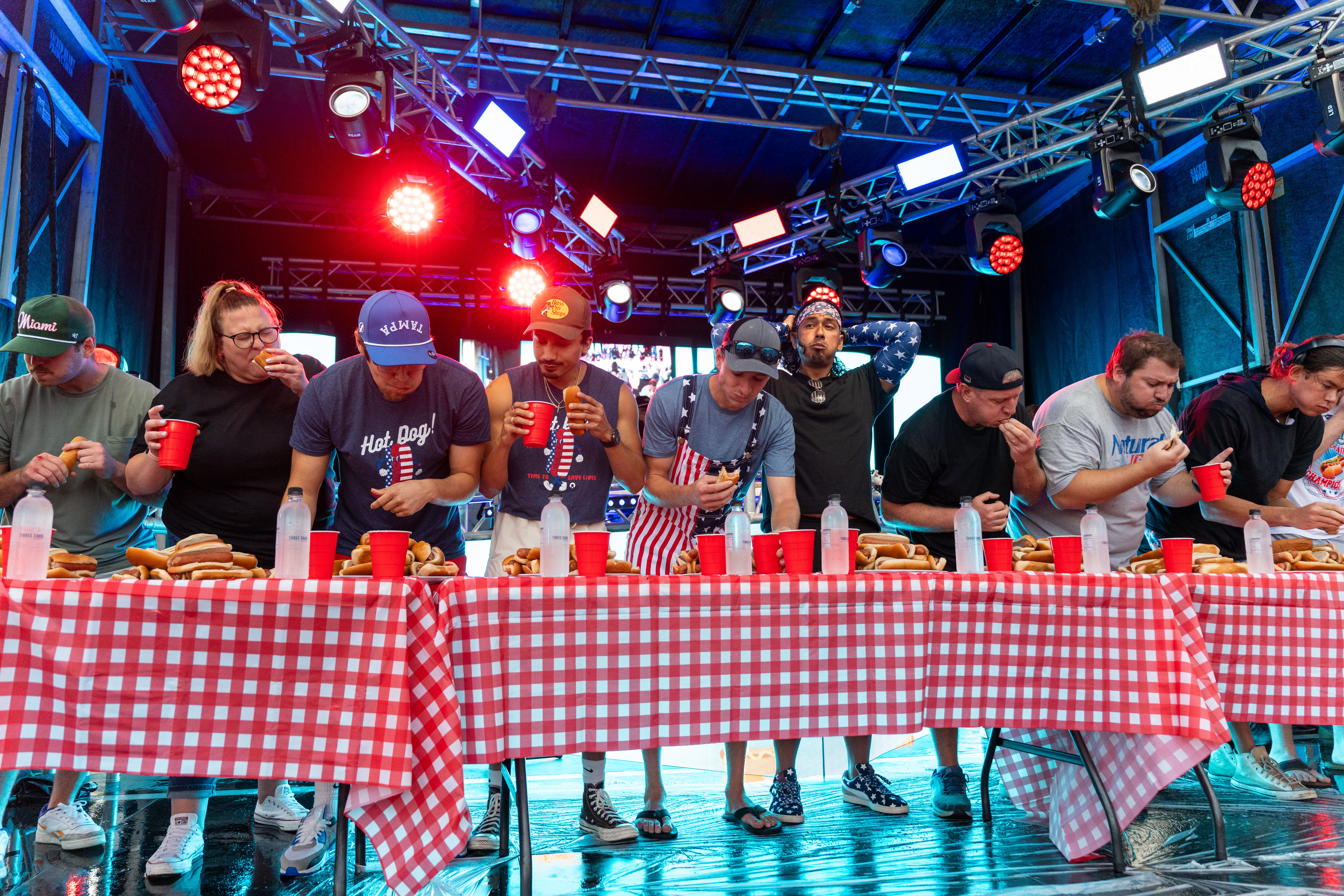 a group of people standing around a table with food and drinks