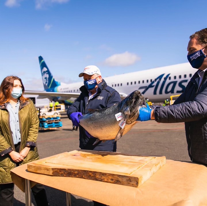 a group of people standing around a plane