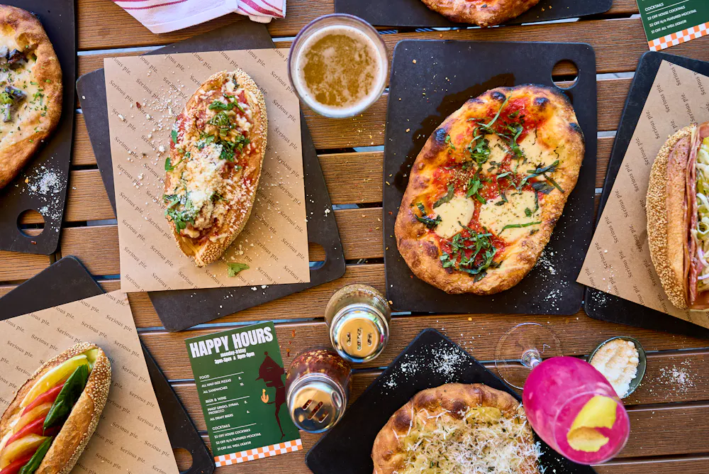 a table with pizzas and drinks