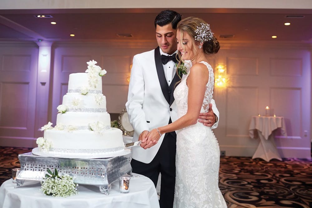 a woman standing in front of a wedding cake