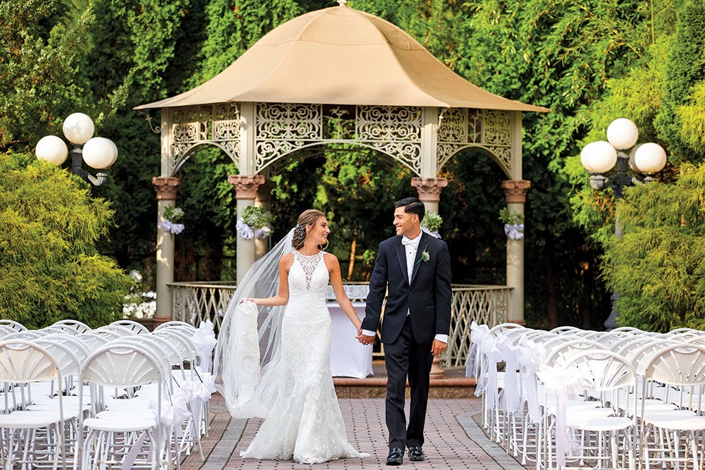 a statue of a man in a suit standing in front of a building