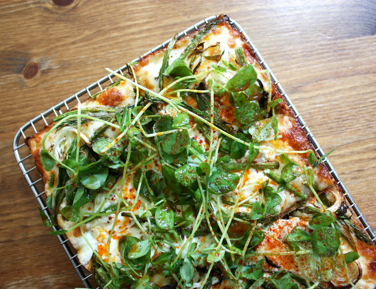 a slice of pizza sitting on top of a wooden cutting board