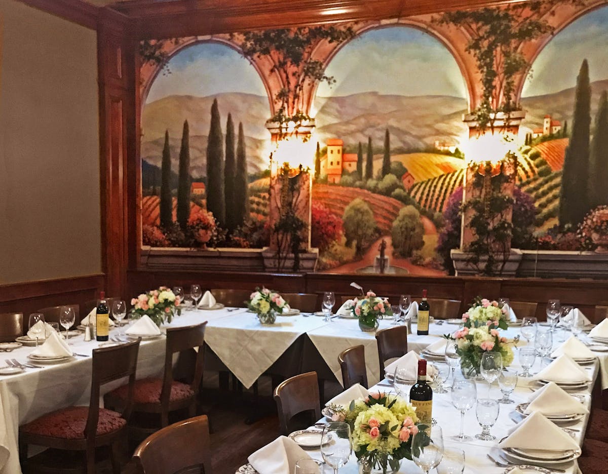 a room filled with furniture and vase of flowers on a table