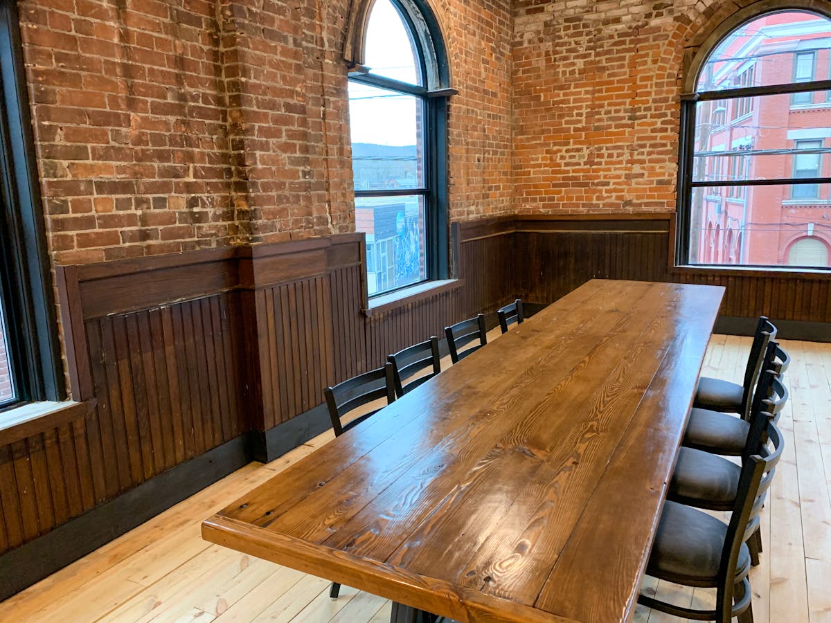 a wooden bench sitting in front of a brick building