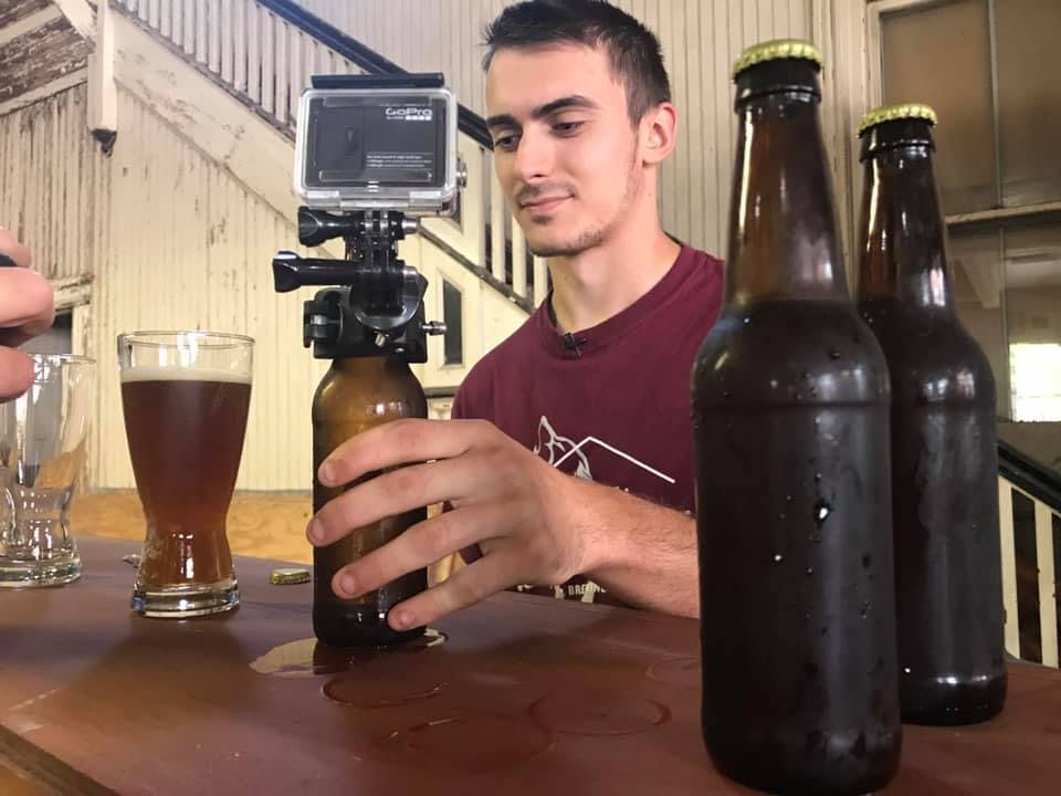 a person holding a glass of beer on a table
