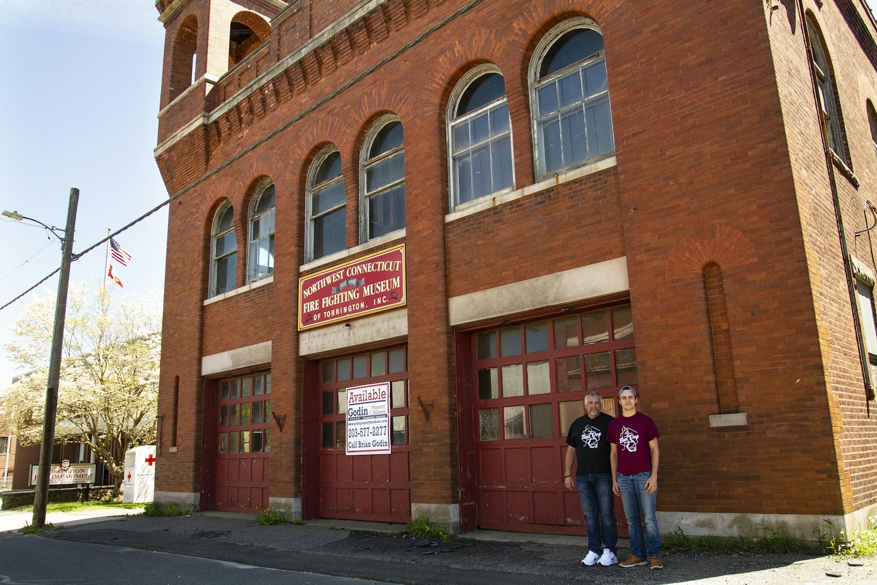 a large red brick tower with a clock on the side of a building