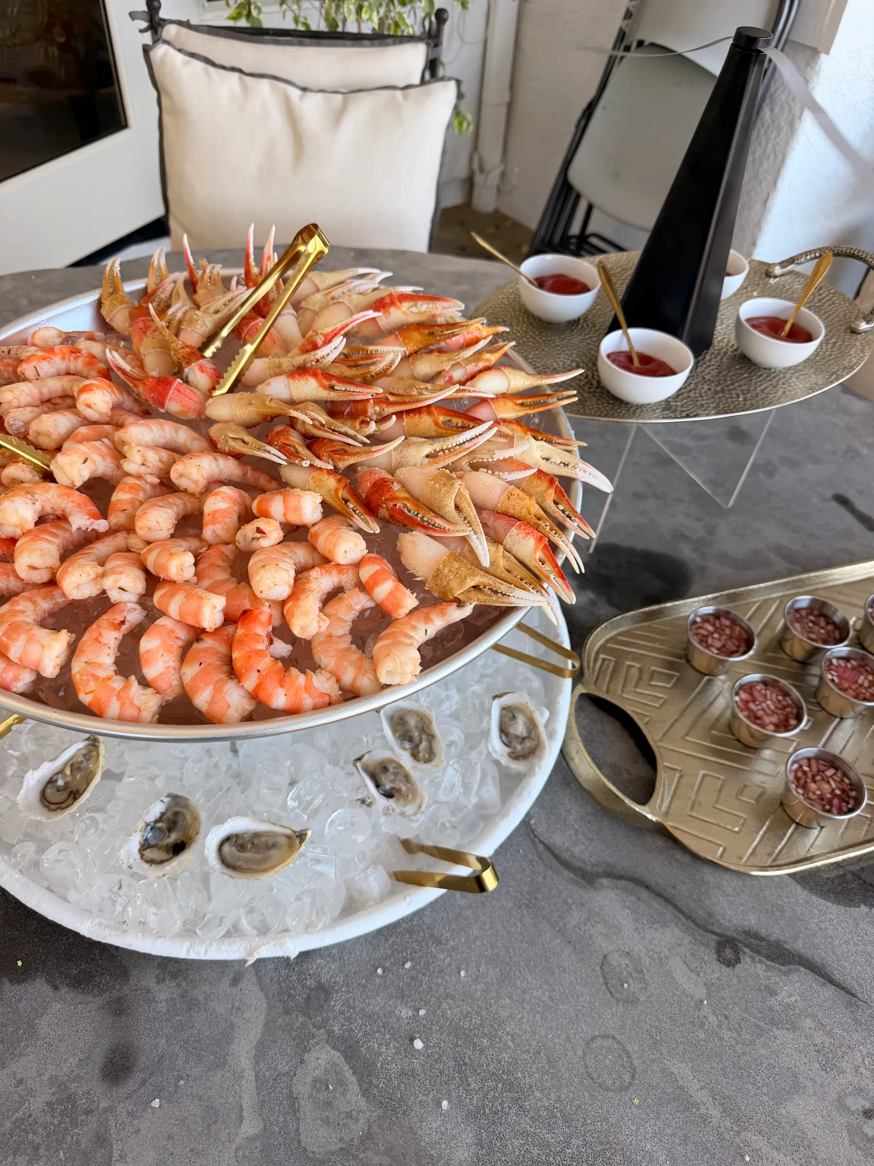 a bowl of shrimp on ice with small bowls of condiments