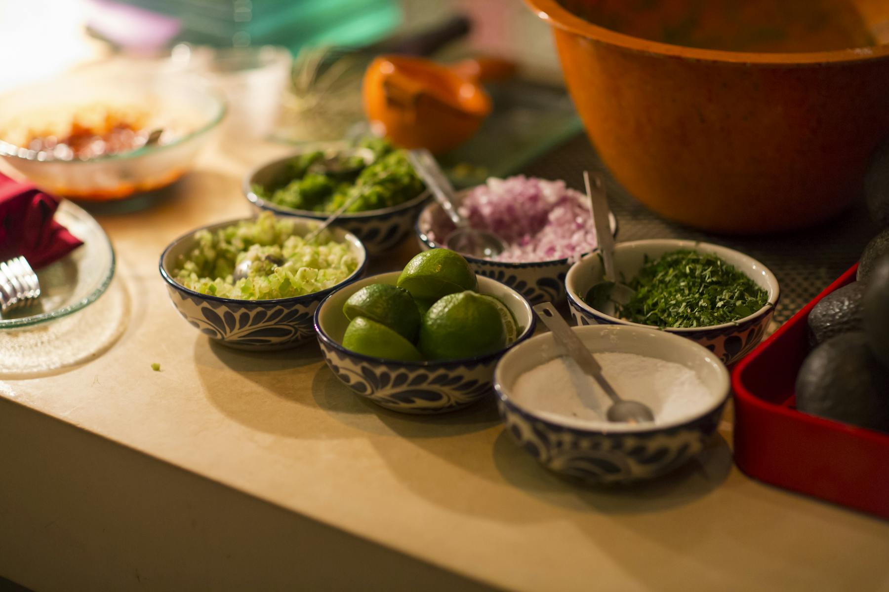 onions, lemons, sauce and cilantro in bowls on a wooden table