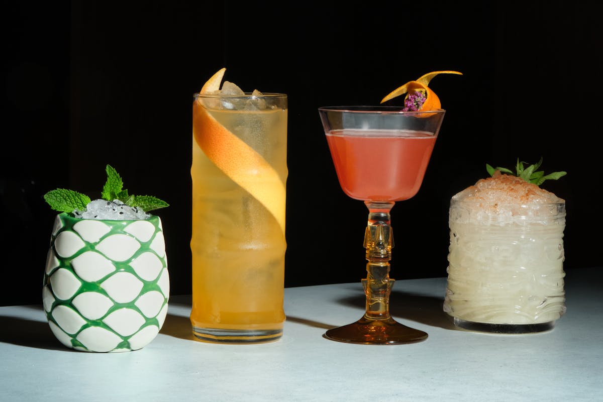 four cocktails of different colors and sizes.