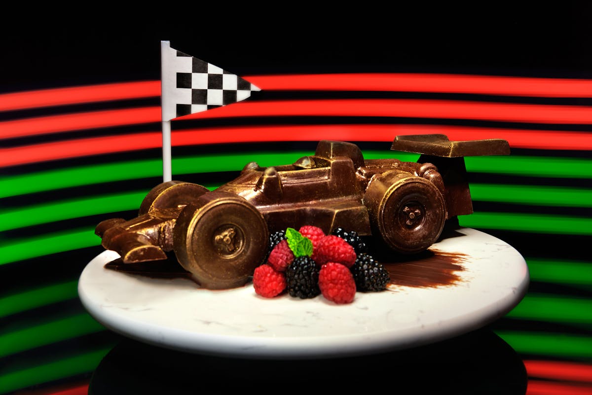 a dessert in the shape of a race car with berries.