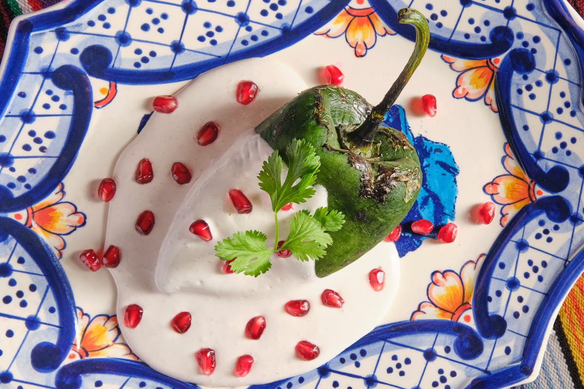 a poblano pepper dressed in walnut-sherry cream sauce sprinkled with pomegranate seeds