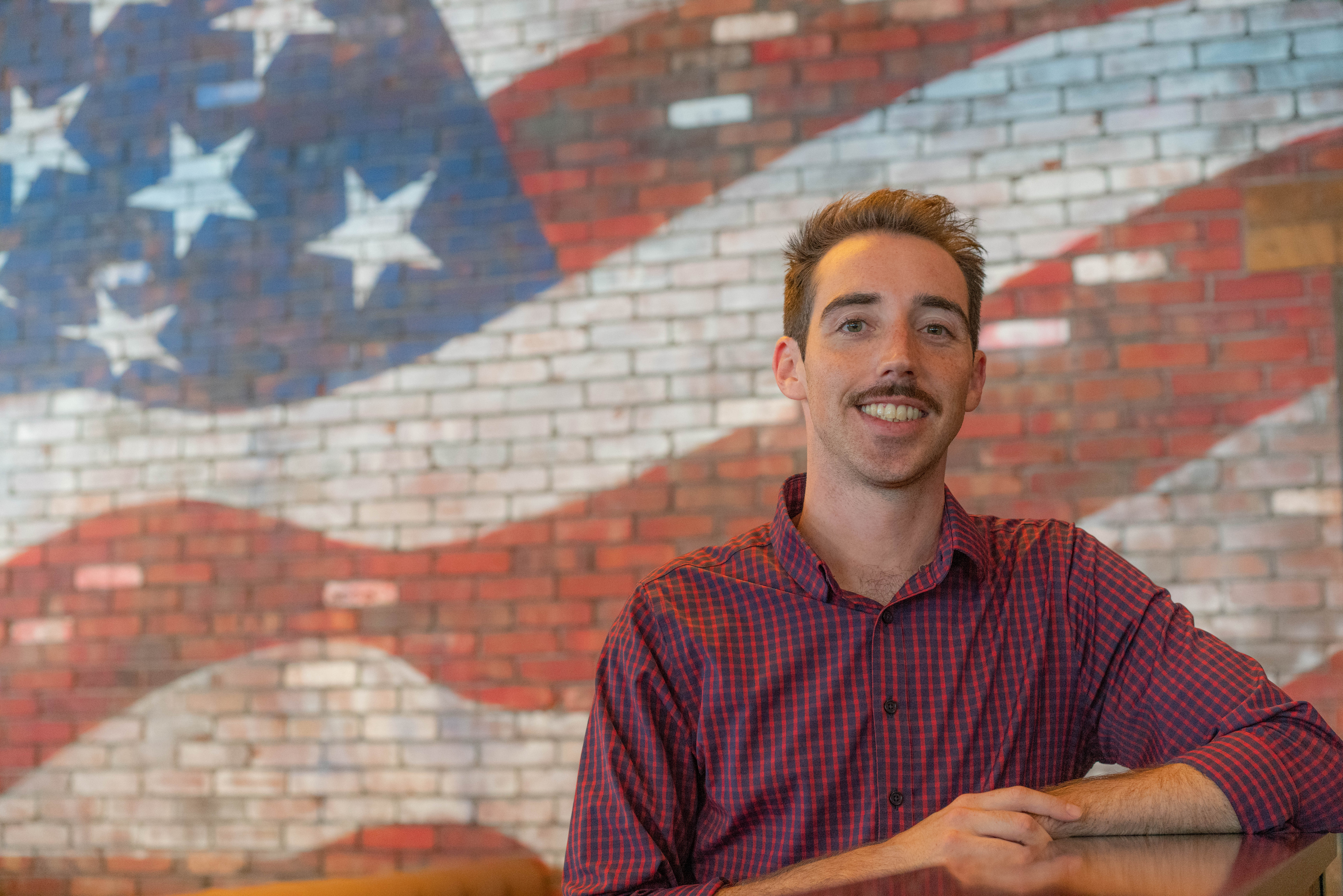 a man standing in front of a brick building