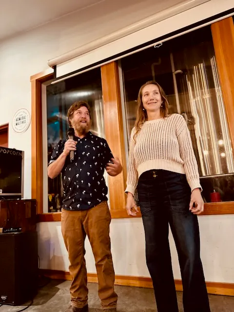 a man and woman standing in front of a window