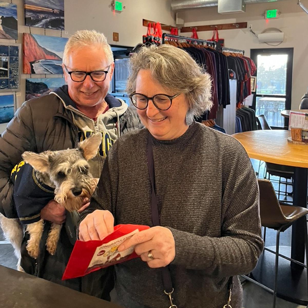 a man and a woman holding a dog