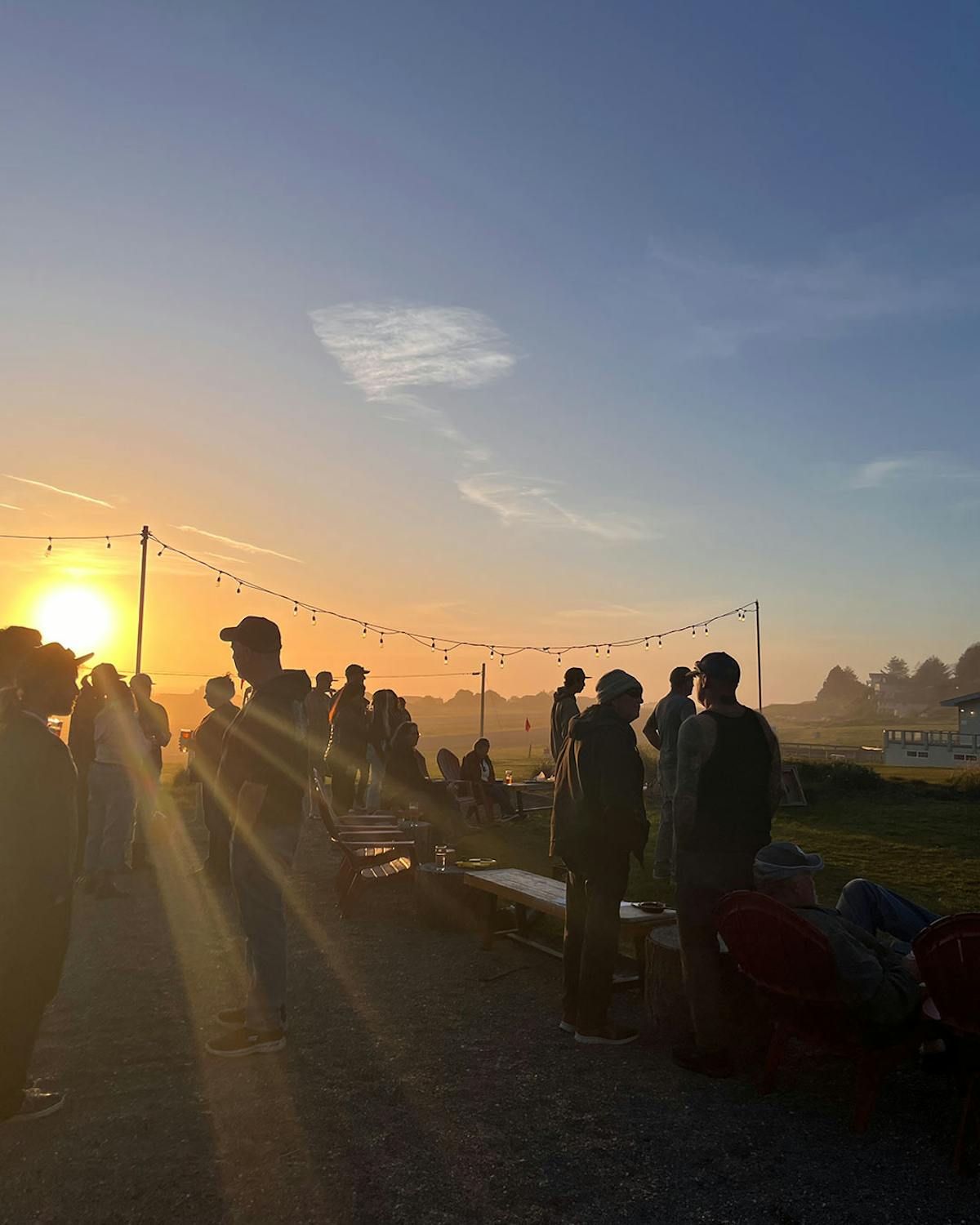 a group of people standing in front of a sunset