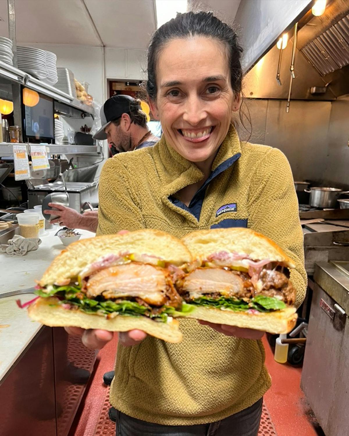 a man holding a sandwich in a restaurant