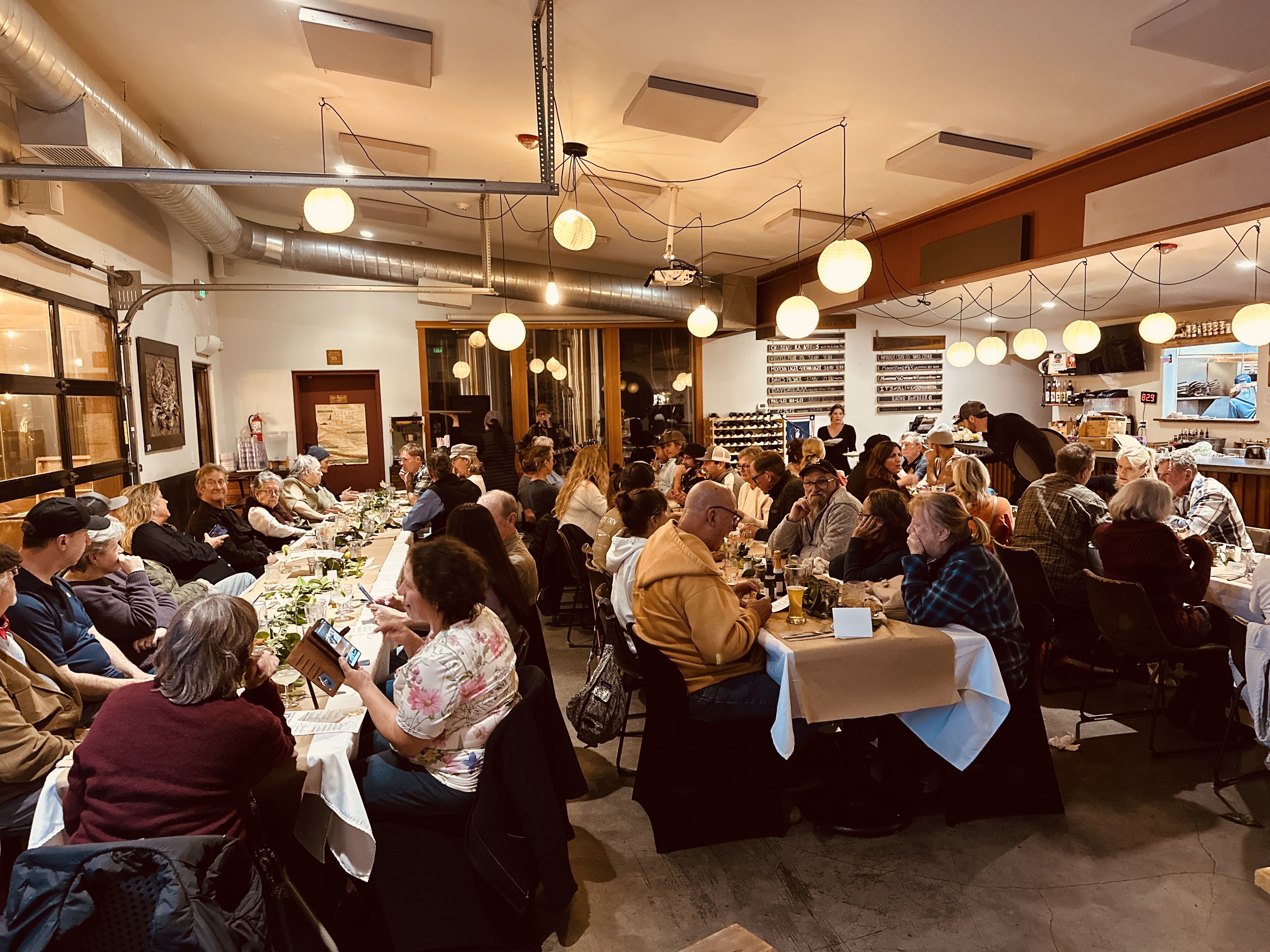 a group of people sitting at tables in a restaurant