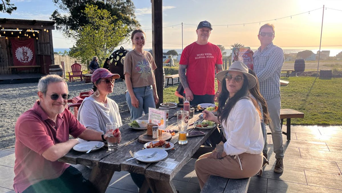 a group of people sitting at a picnic table