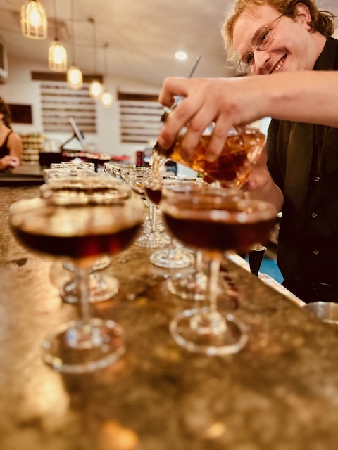 a person pouring alcohol into glasses