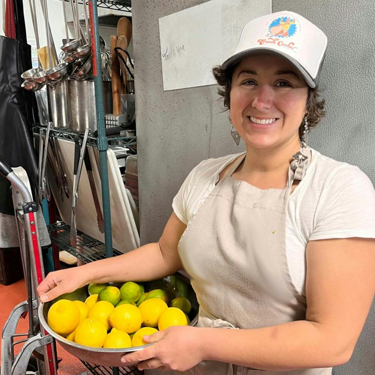 a woman sitting at a fruit stand
