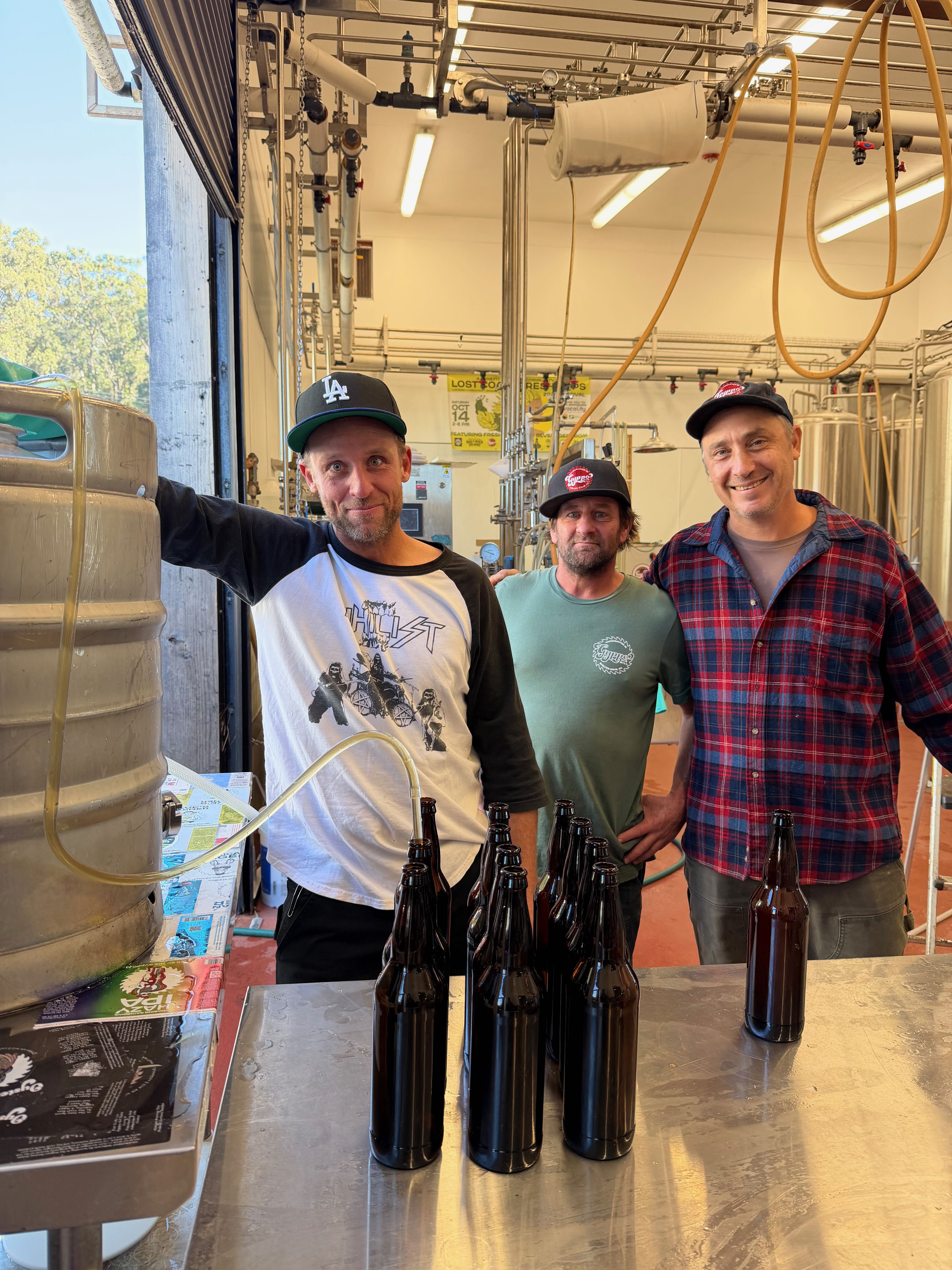 a group of people standing next to a bottle of wine