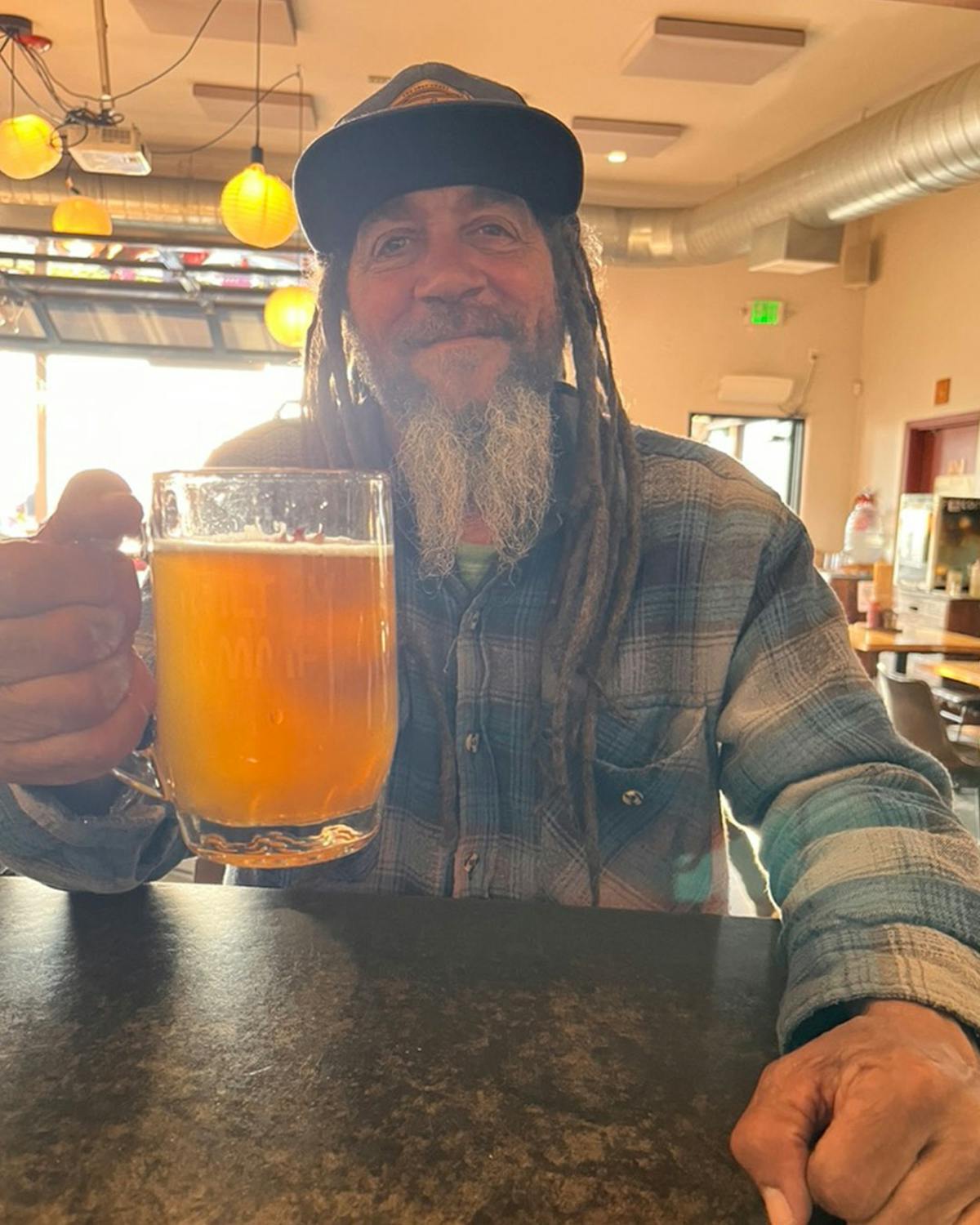 a person holding a glass of beer on a table