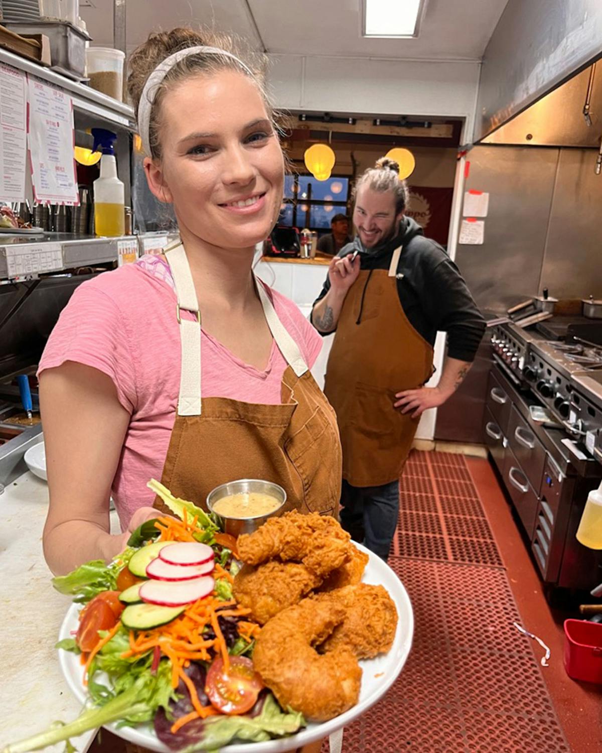 a woman holding a plate of food on a table