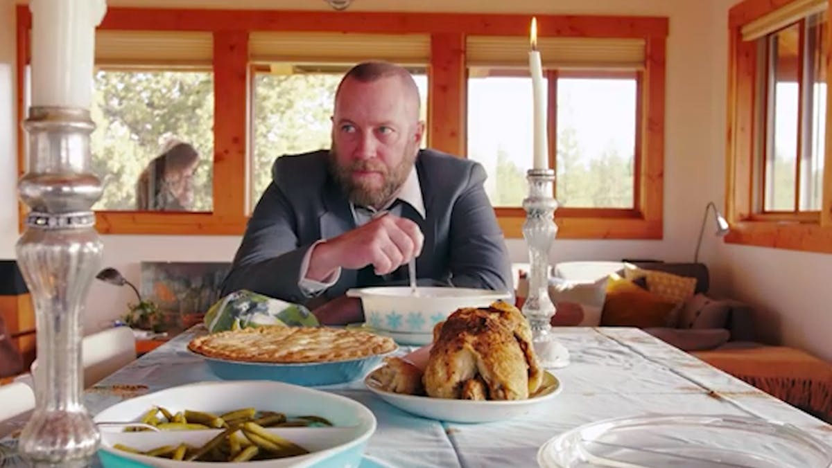 a person sitting at a table with a plate of food