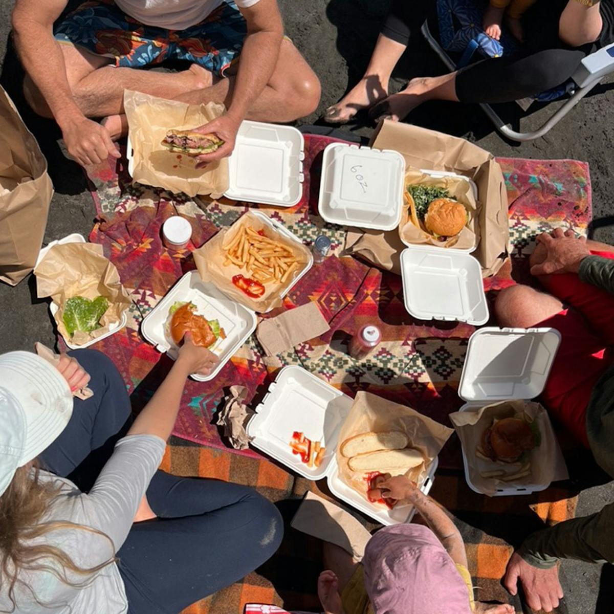 a group of people sitting at a table with food