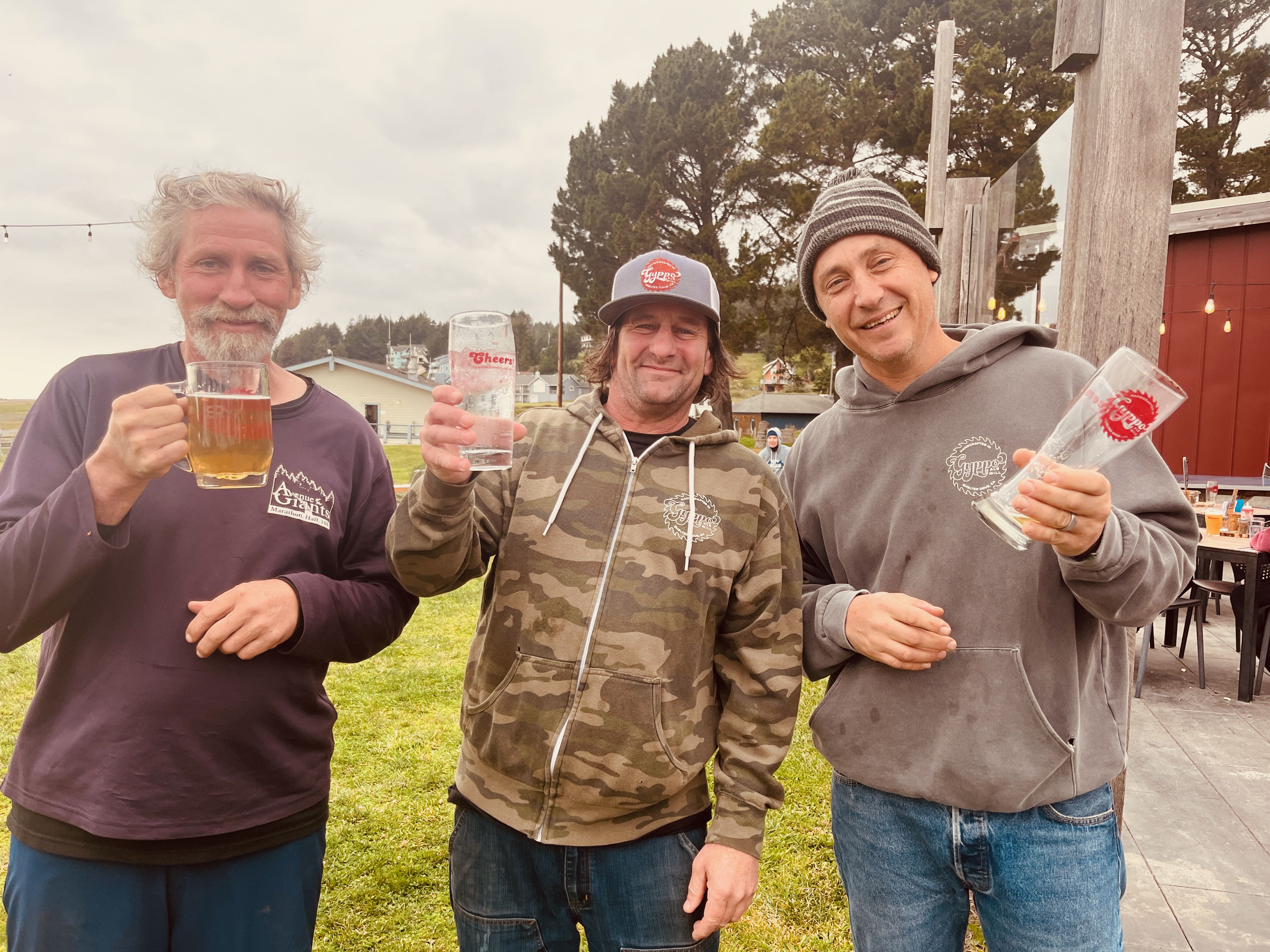 a group of men holding up glasses of beer
