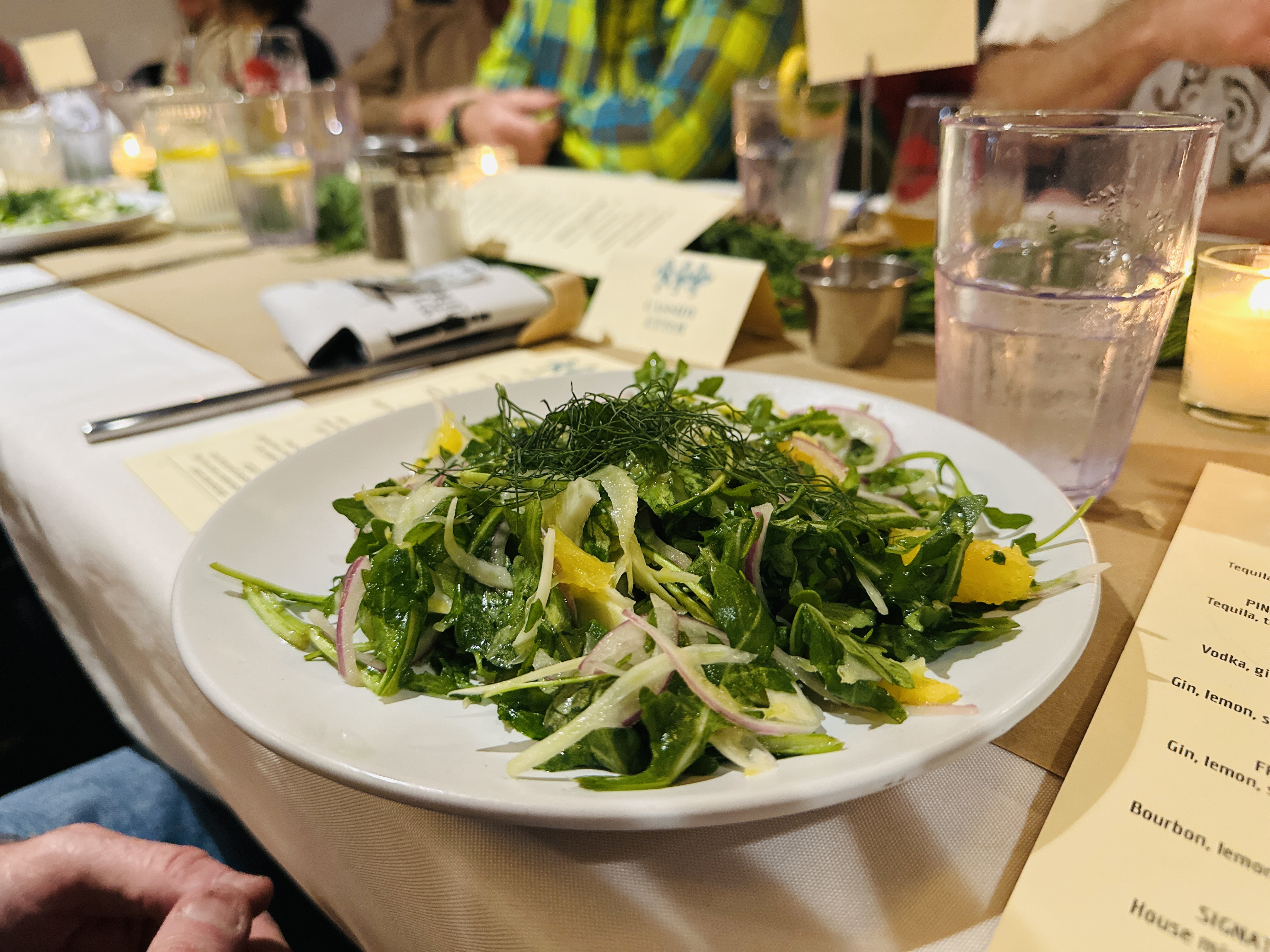 a person sitting at a table with a plate of food with broccoli