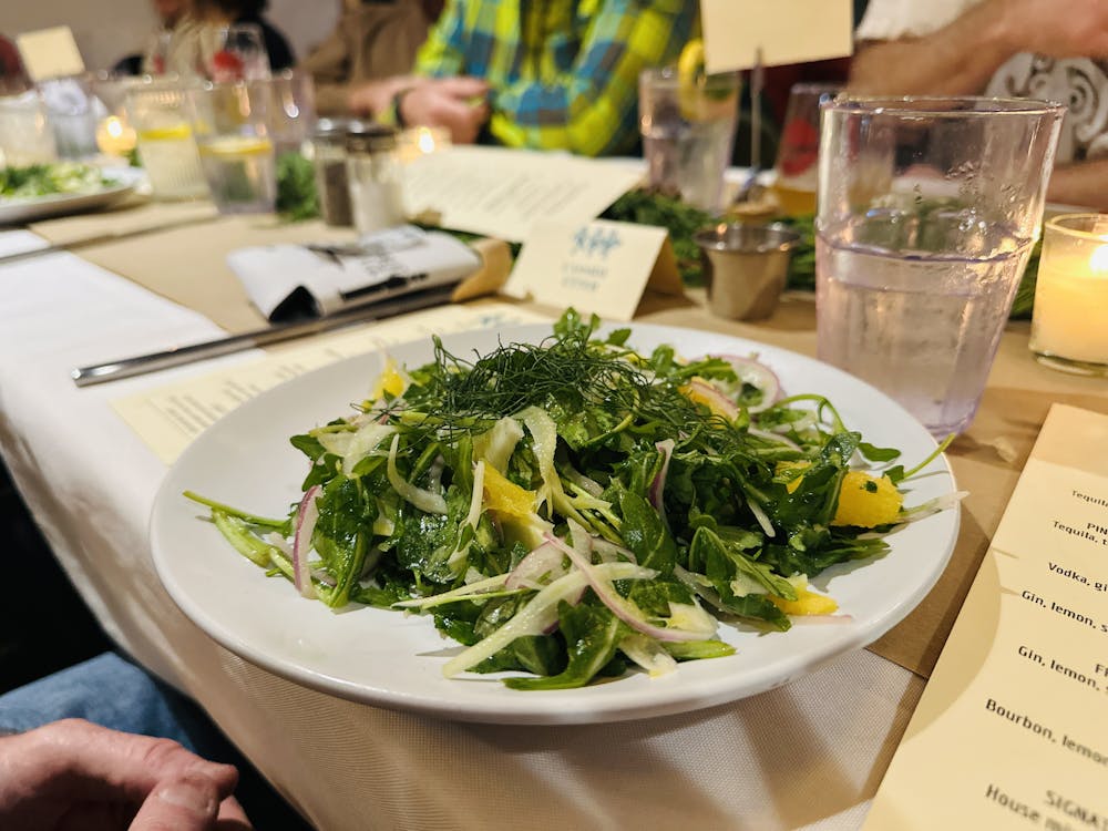 a person sitting at a table with a plate of food with broccoli