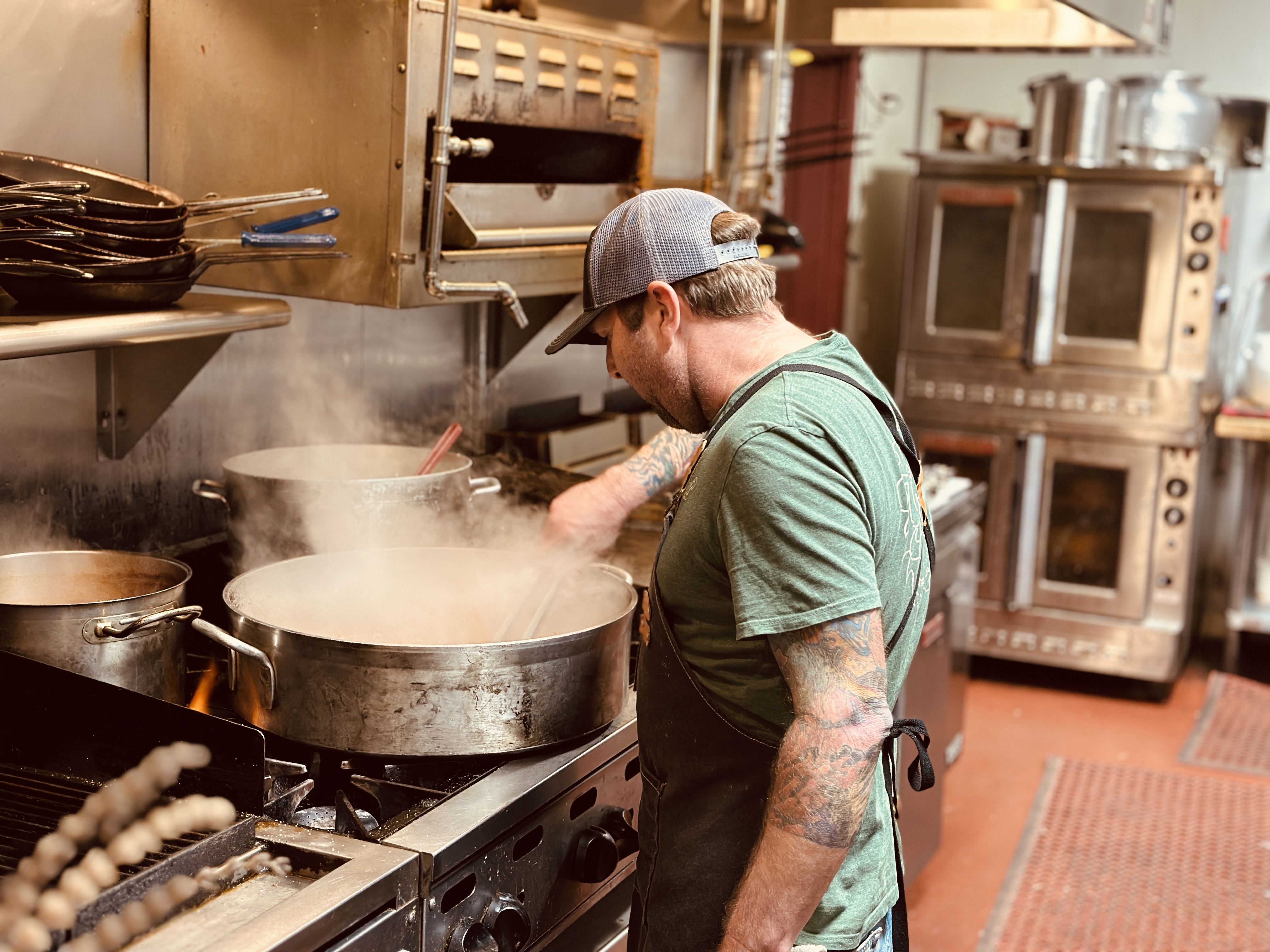 a man cooking food in a pan on a stove