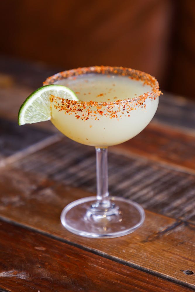 a glass of wine sitting on top of a wooden table
