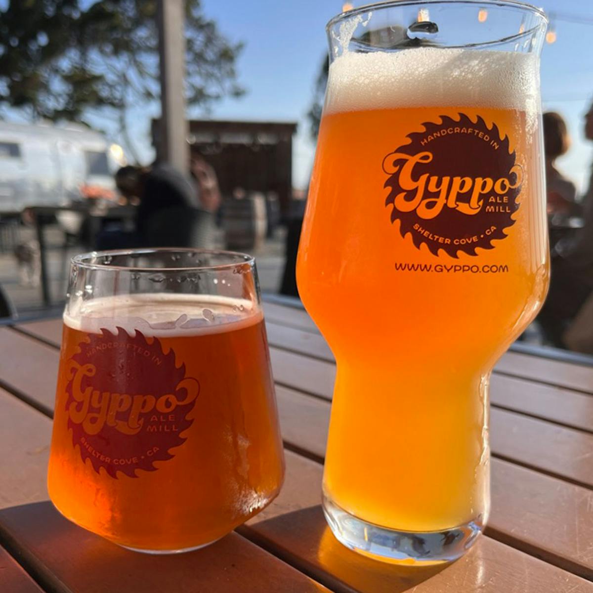 a glass of orange juice next to a cup of beer