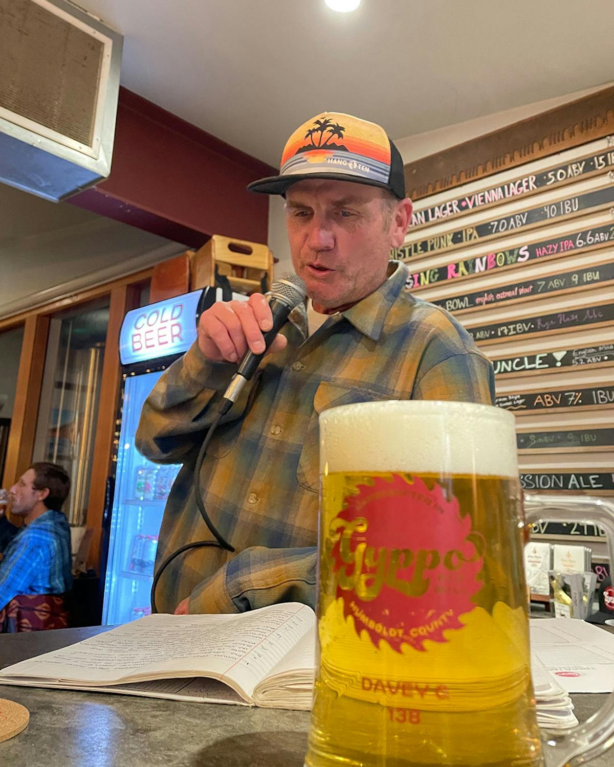 a man drinking a glass of beer on a table
