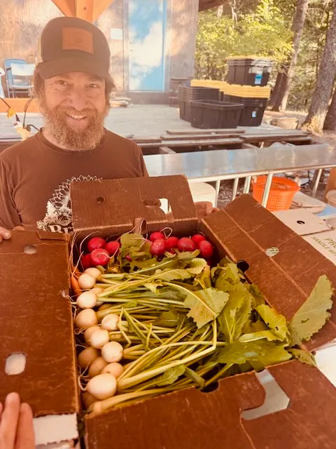 a man holding a box of vegetables
