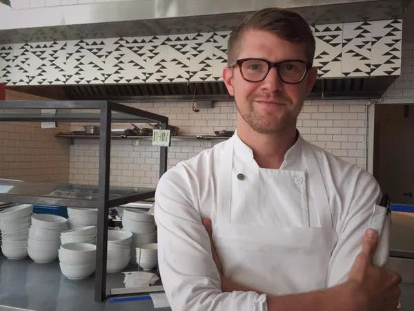 Photo of man with glasses in front of kitchen