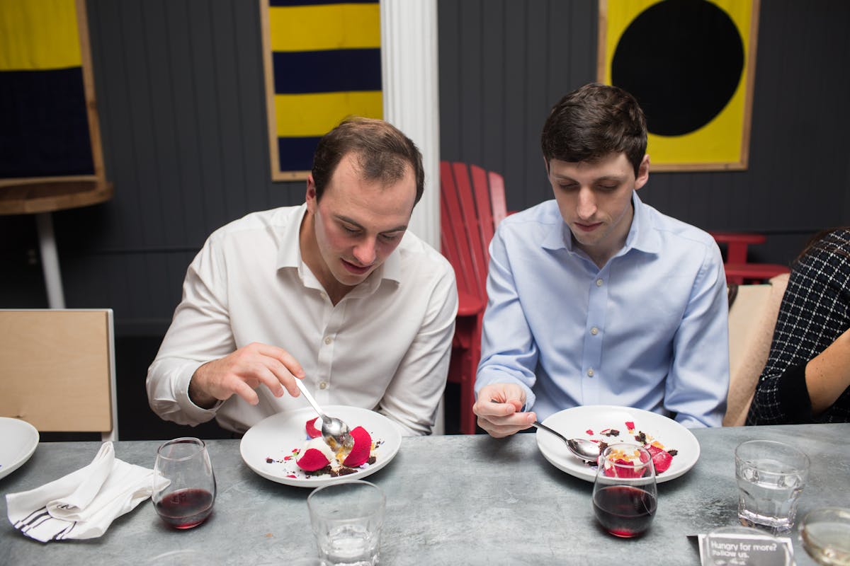 a group of people sitting at a table eating food